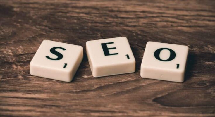 A group of white tiles with black letters on a wooden surface, illustrating key SEO tips.