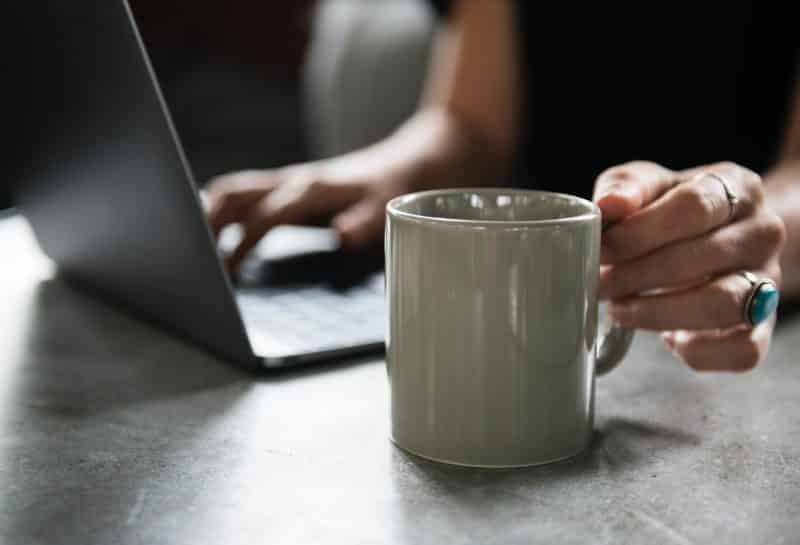 A person holding a coffee cup, exploring 3 Tech Hacks to make life a little easier.