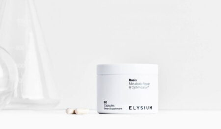 A container of Elysium Health dietary supplement labeled "metabolic repair & optimization" with two capsules beside it, set against a minimalist white background.