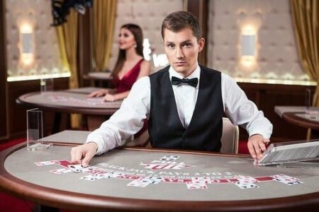 A casino dealer in a tuxedo arranges cards on a poker table, with tips on how to choose the right online casino displayed in the background, suggesting a sophisticated gaming atmosphere.