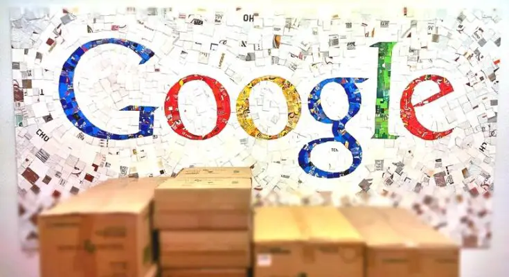 A colorful Google Classroom logo made up of various photographs and images on a wall, with stacks of cardboard boxes in the foreground.