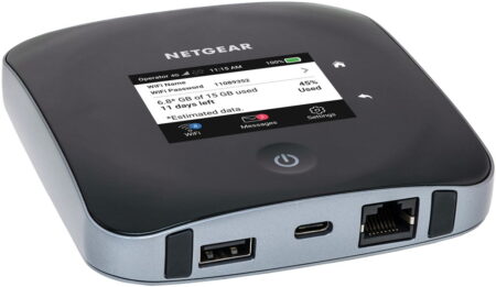 A Netgear Nighthawk mobile hotspot device displaying data usage and network information on its screen, with USB and Ethernet ports visible.