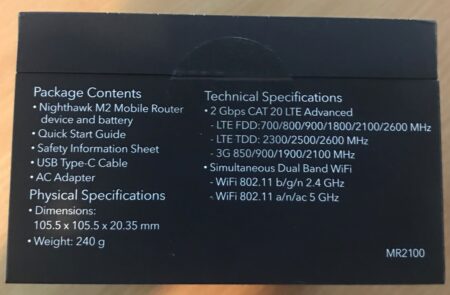 An image displaying the packaging of a Netgear Nighthawk M2 mobile router. The package lists contents, technical specifications, physical dimensions, and weight.