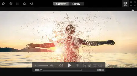 A person joyfully splashes water with outstretched arms in a lake at sunset, creating a silhouette against the vibrant sky. Visible 5KPlayer controls overlay the image.