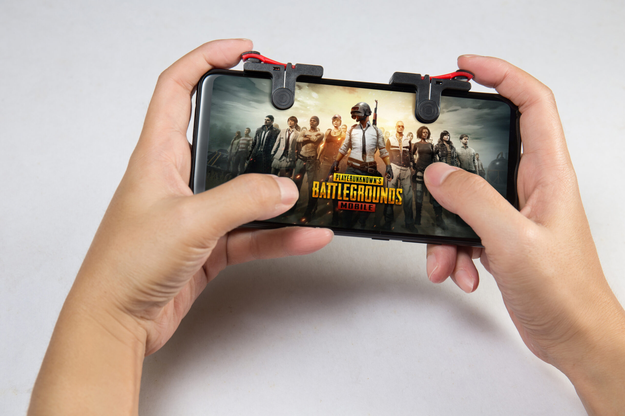 Hand holding a smartphone with Player's Unknown Battleground also known as PUBG online shooting gaming
