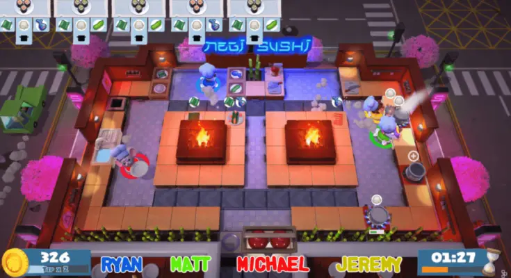 Overhead view of the colorful, animated "Overcooked" video game, showing characters cooking in a kitchen with two central fire pits, surrounded by counters and cherry blossom trees. Player names and scores are