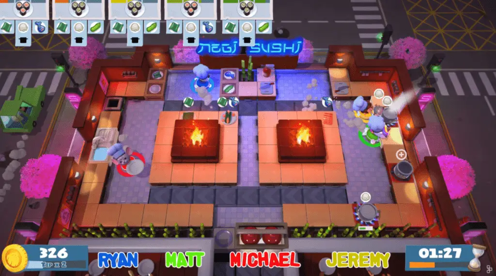 Overhead view of the colorful, animated "Overcooked" video game, showing characters cooking in a kitchen with two central fire pits, surrounded by counters and cherry blossom trees. Player names and scores are