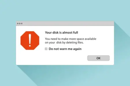 A computer error message on a Mac in a window that reads "your disk is almost full. You need to make more space available on your disk by deleting files. Do not warn me again" with