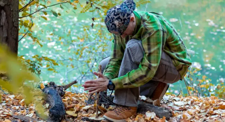 Man in the woods starting a fire