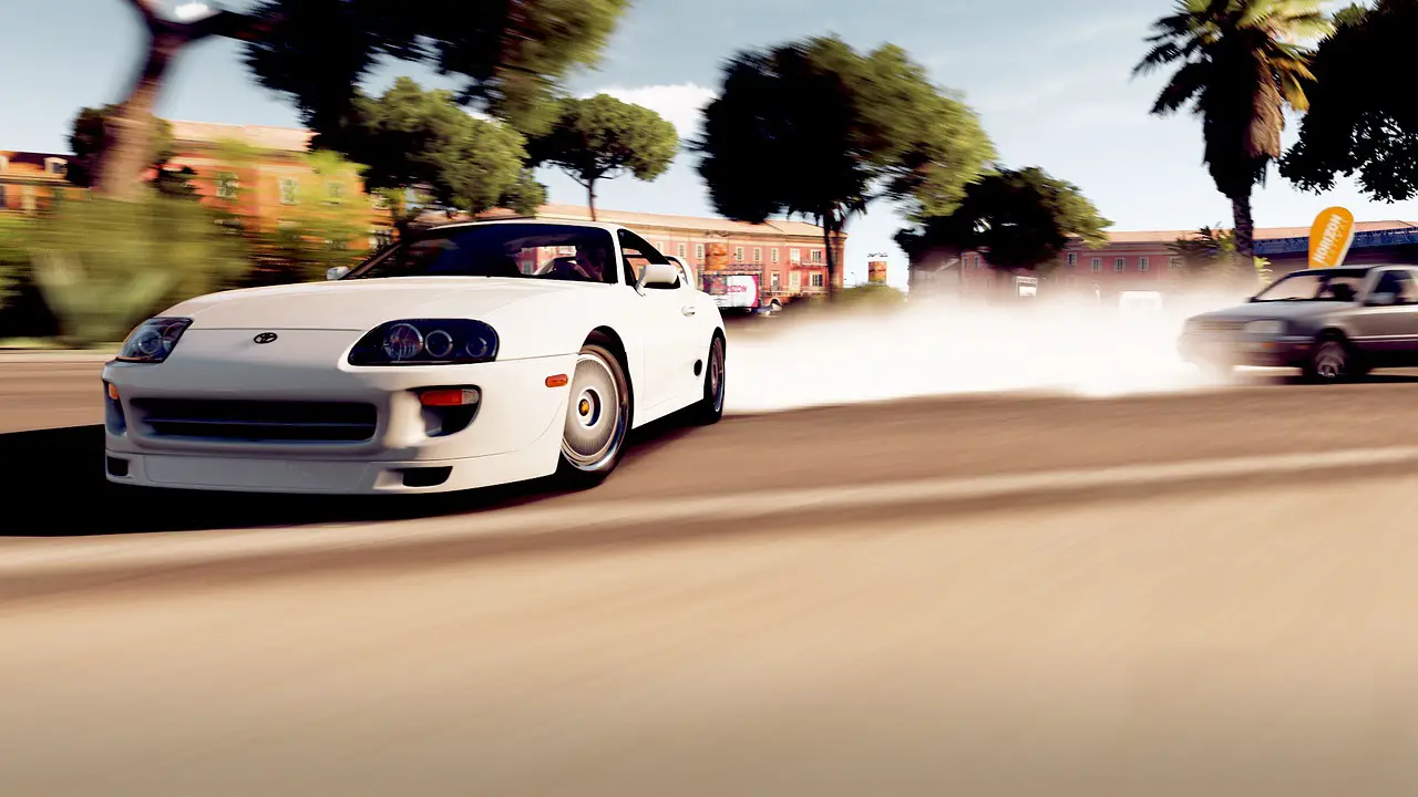 White sports car performing a dynamic drift in a video game setting on a sunny street lined with trees and colorful buildings, creating a trail of tire smoke.