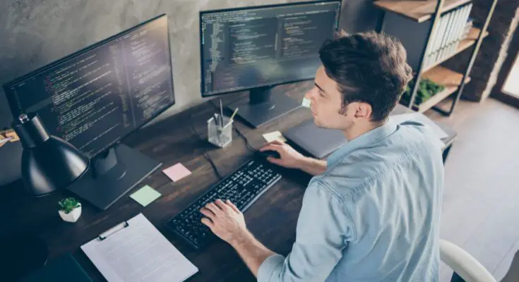 Top above high angle view portrait of his, he nice attractive focused skilled geek guy typing bug track report cyberspace security at modern industrial interior style concrete wall work place station