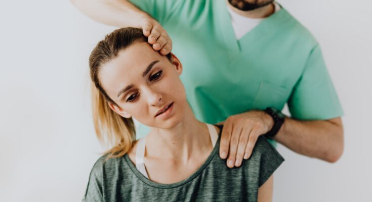 professional massage therapist treating a female patient s injured neck