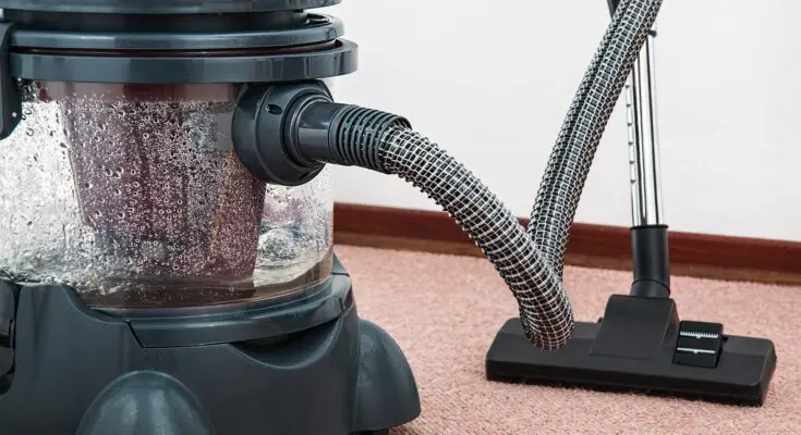 black and red canister vacuum cleaner on floor