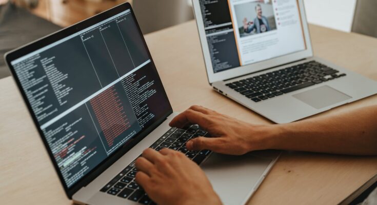 person coding on a macbook pro