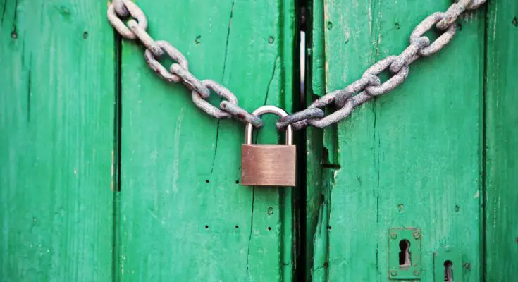 brass colored metal padlock with chain