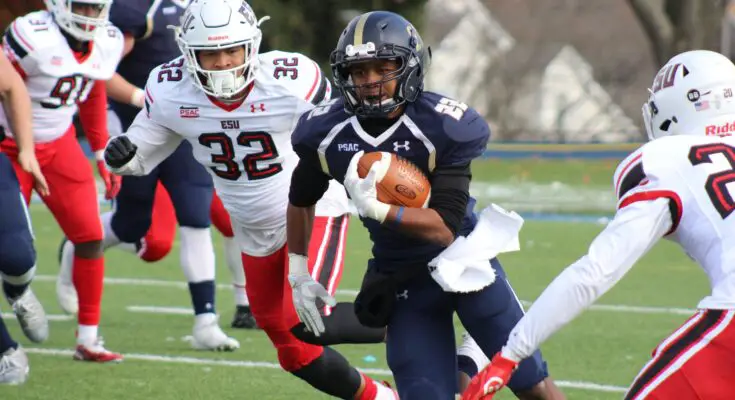 football player carrying brown football