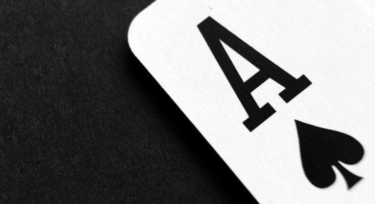 ace of spade playing card on grey surface