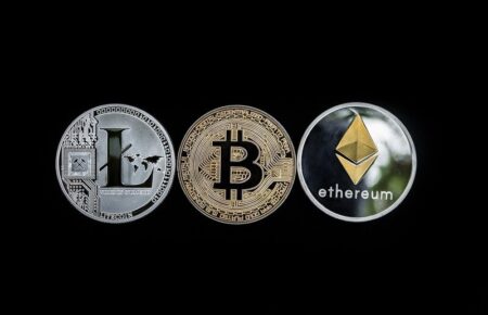 Three cryptocurrency coins isolated on a black background: litecoin, bitcoin, and ethereum, shown from left to right, each featuring their distinct logos, reminiscent of jackpot slots symbols.