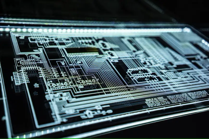 Illuminated cybersecurity circuit board design with intricate pathways and electronic components displayed in blue and white tones against a dark background.