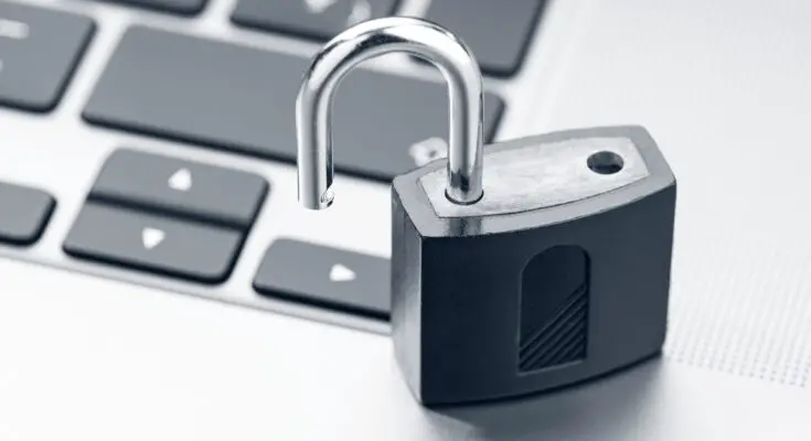 A close-up of an open silver padlock on a laptop keyboard, symbolizing data security in the context of open access publications.