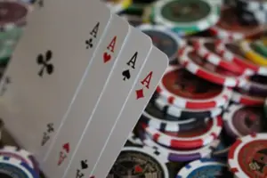 Four aces fanned out with colorful poker chips blurred in the background on a table, challenging myths about bad poker hands.