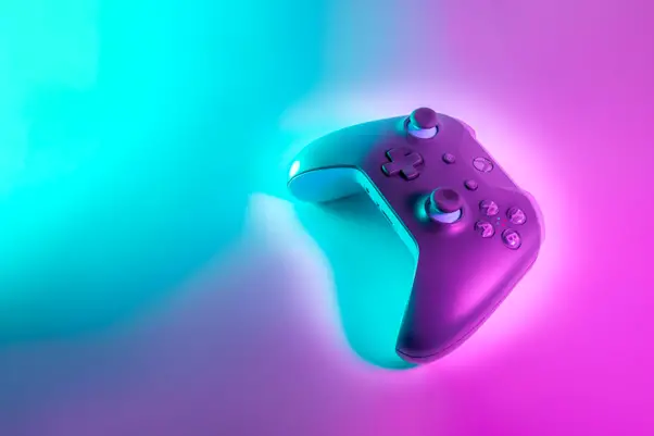 A gaming controller illuminated by neon purple and blue lights, casting a vibrant glow on a smooth surface, creating a modern and techy atmosphere in the world of OSRS Gold.