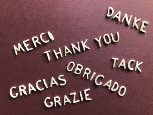 Languages "thank you" in various tongues, including "merci," "danke," "tack," "gracias," "obrigado," and "grazie," arranged on a