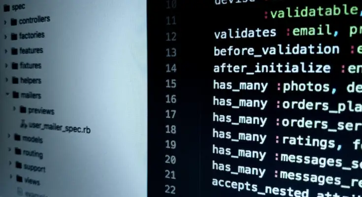 A computer screen displaying code from a Ruby on Rails application, highlighting models and database validations in a software engineering context, with slight blurring on the left side.