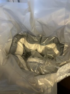 A close-up view of the inside of a white, plastic Simba garbage bag with various crumpled wrappers and clear plastic materials inside. The focus is on the textures and folds of the materials.