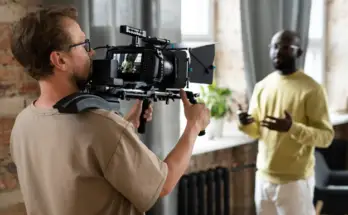 a man holding a camera to a man's shoulder