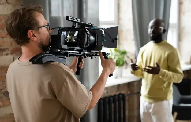 a man holding a camera to a man's shoulder